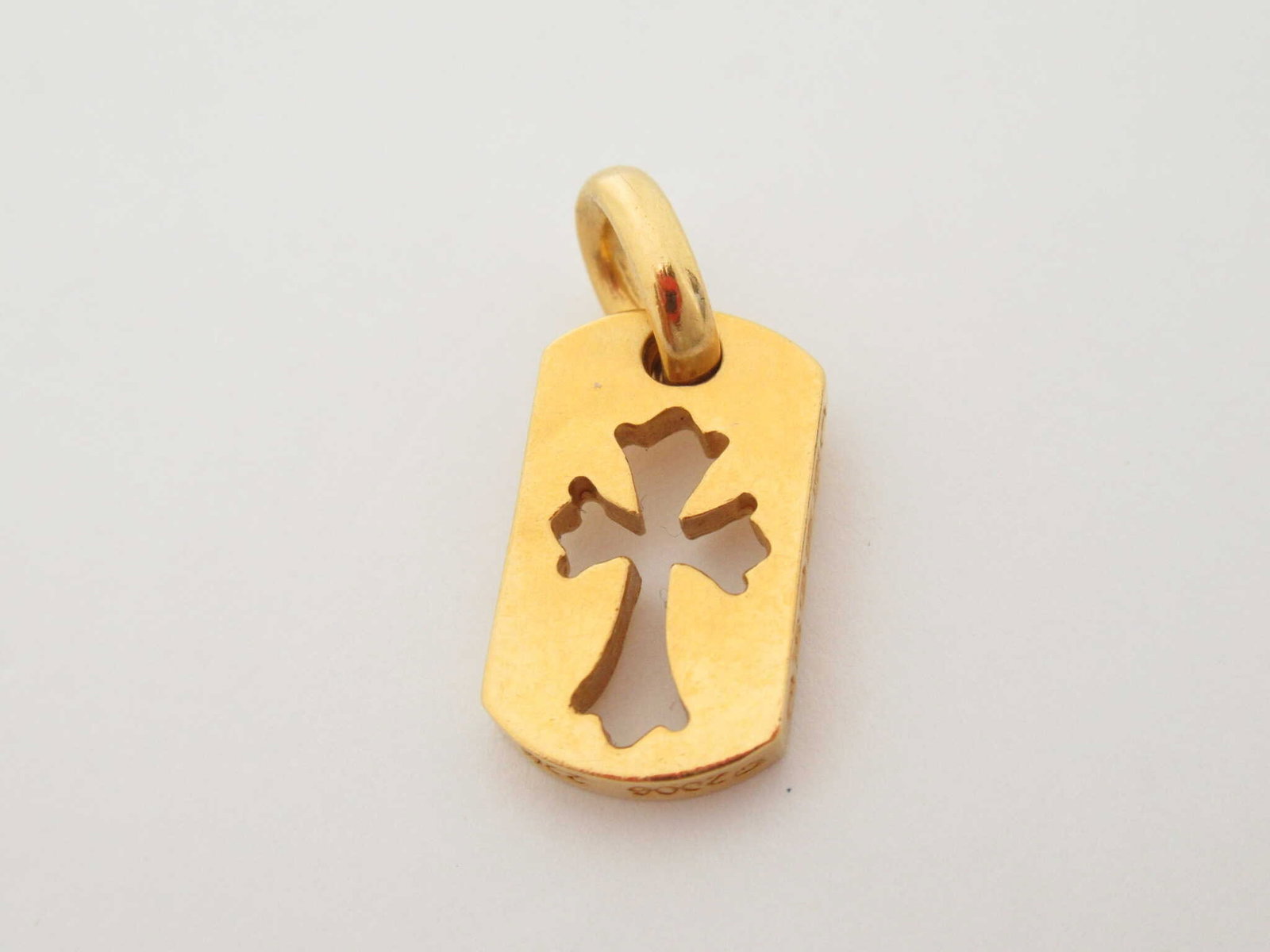Chrome Hearts Tiny Cut Out Cross 22K Gold Pendant: Description: Iconic Chrome Hearts tiny cut out cross pendant crafted in solid gold, featuring the brand’s signature gothic cross silhouette set within a rectangular plaque form. The clean cut out de