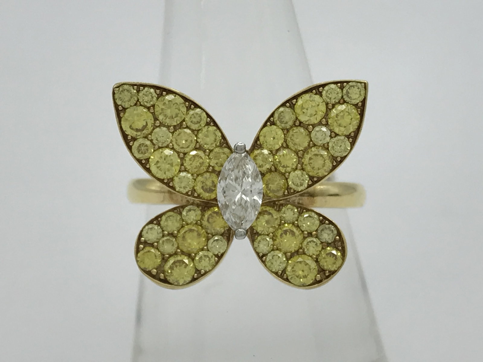 Graff Pave Butterfly Yellow Diamond and Diamond 18K Yellow Gold Ring: Description: An elegant Graff Butterfly ring crafted in 18K yellow gold and set with vibrant yellow diamonds in a pave butterfly motif. The design is centered by a marquise cut white diamond, creating