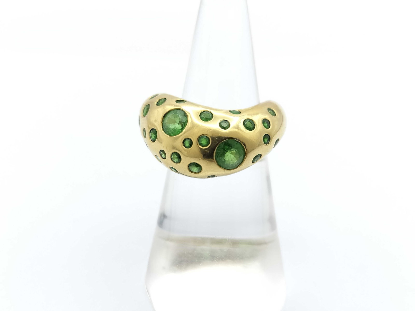 Fred Flushed Set Emerald 18K Yellow Gold Dome Ring: Description: Bold Fred ring crafted in solid 18K yellow gold featuring a sculptural dome design set with vibrant green gemstones throughout. The playful arrangement of larger and smaller stones create