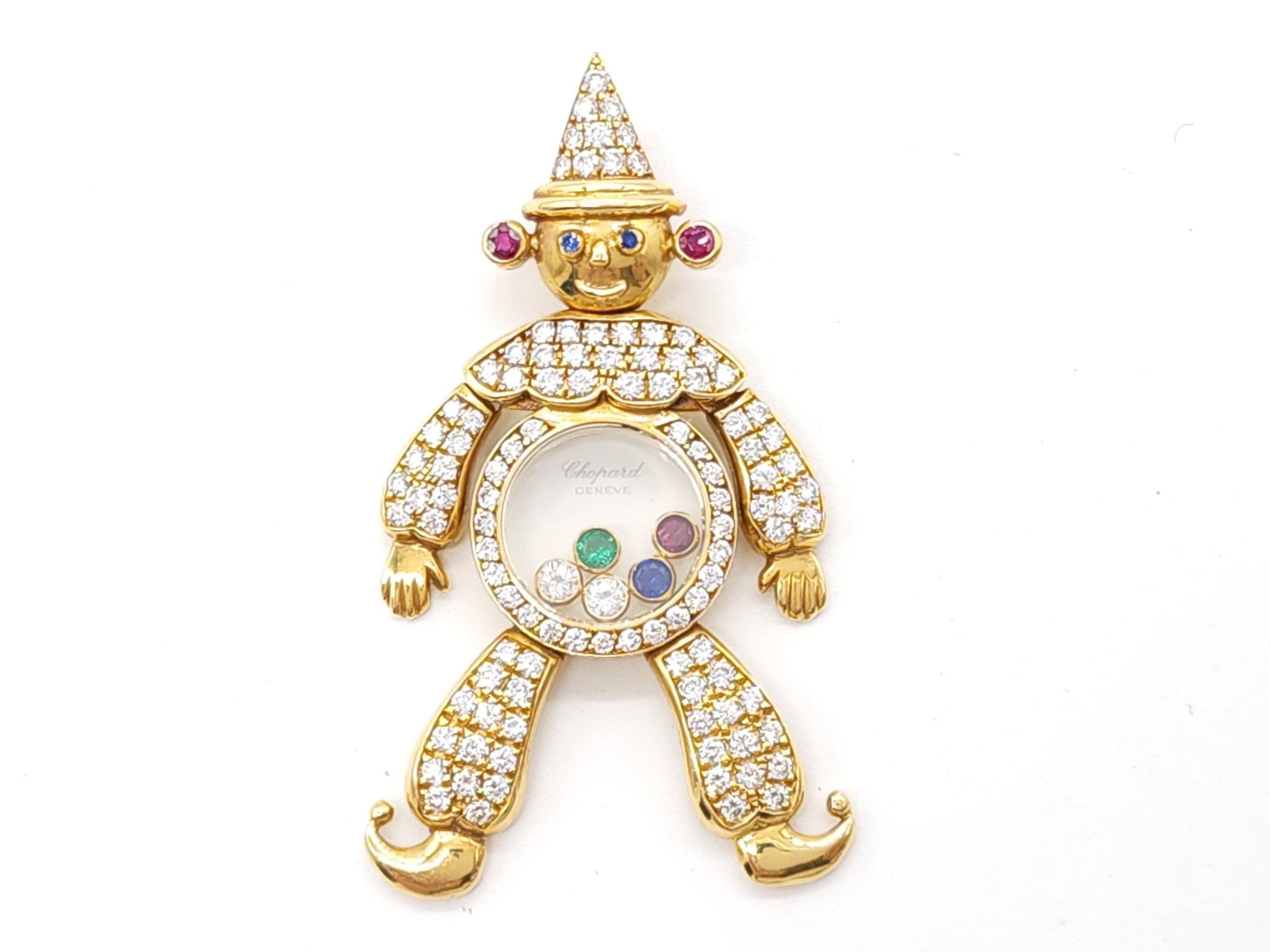 Chopard Happy Diamonds Crown Ruby Sapphire Emerald Diamond 18K Yellow Gold Pendant: Description: Exceptional and rare Chopard Happy Diamonds crown clown pendant crafted in solid 18K yellow gold, featuring an articulated clown figure richly set with natural diamonds and accented by ru