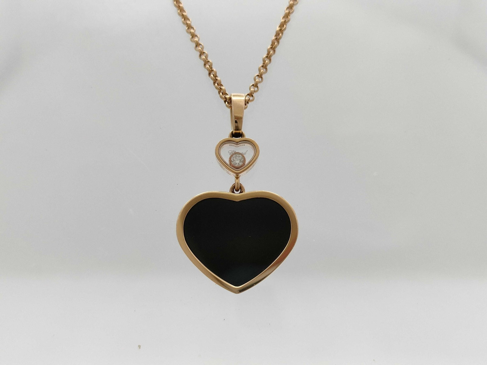 Chopard Happy Hearts Black Onyx Diamond 18K Rose Gold Necklace: Description: This elegant Chopard Happy Hearts necklace is crafted in solid 18K rose gold and features a polished black heart motif pendant suspended below a smaller heart containing a single floating