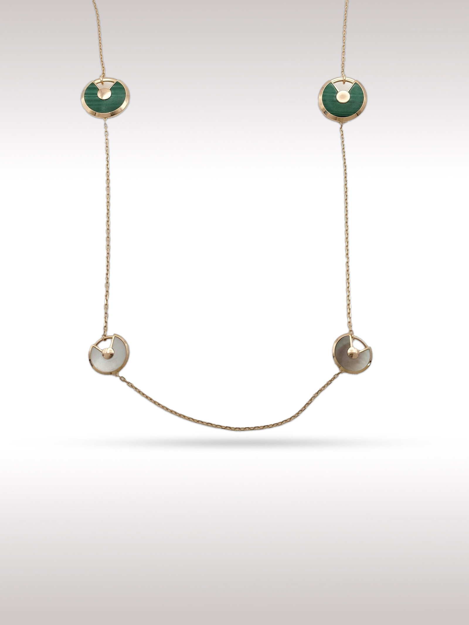 Cartier Amulette Malachite Mother of Pearl Diamond 18K Rose Gold Long Station Necklace: Description: Elegant Cartier Amulette long station necklace crafted in 18K rose gold, featuring a series of circular motifs set with vibrant green malachite and luminous mother of pearl. Each motif is
