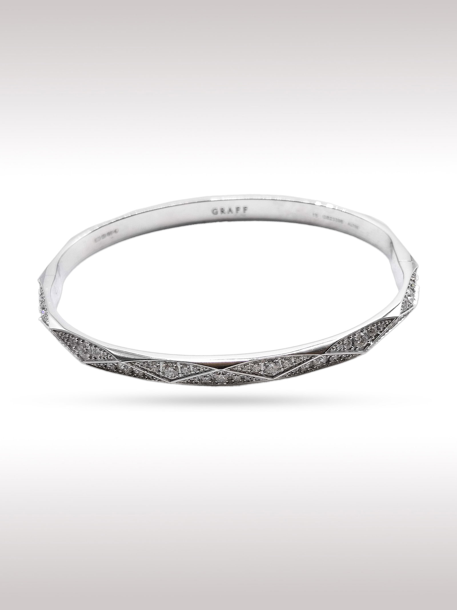 Graff Signature Diamond 18K White Gold Bangle Bracelet: Description: Elegant Graff Signature bangle bracelet crafted in 18K white gold, featuring a refined geometric design set with brilliant cut diamonds. The central section showcases an intricate criss c