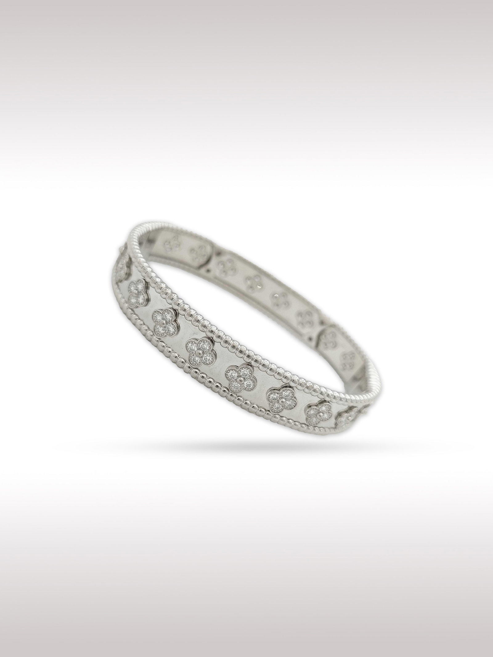 Van Cleef & Arpels Perlee Diamond Clovers 18K White Gold Bangle Bracelet: Description: Elegant Van Cleef Arpels Perlee bangle bracelet crafted in 18K white gold, featuring the Maison signature beaded gold border design accented with delicate clover motifs set with