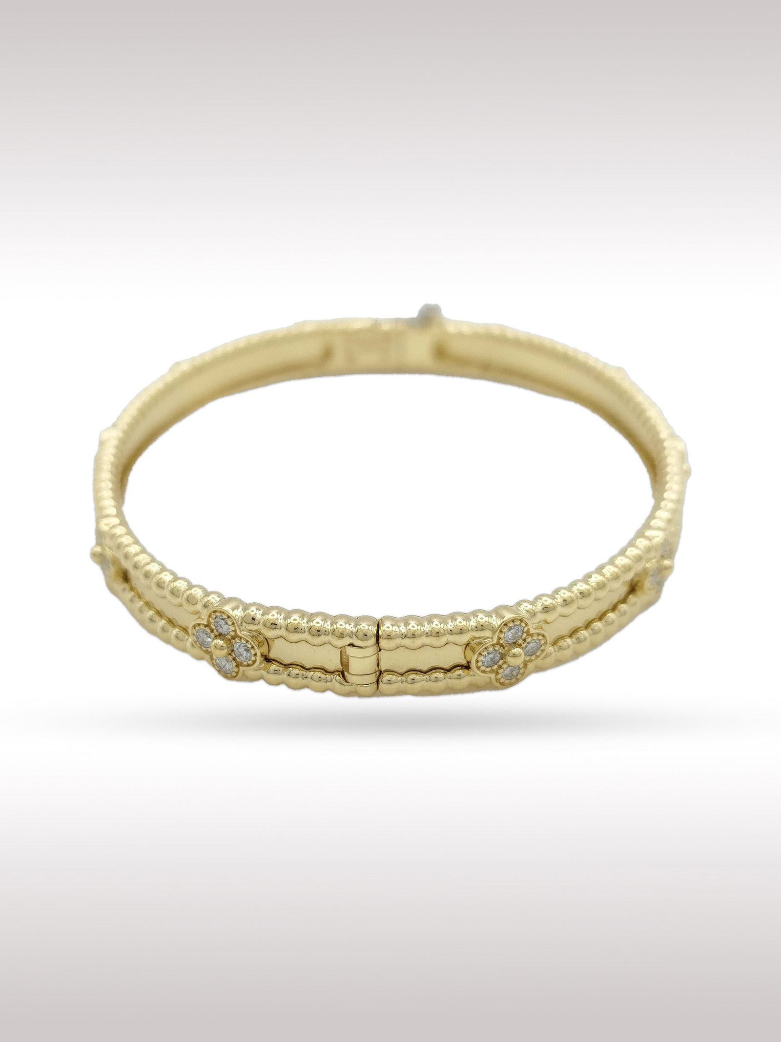 Van Cleef & Arpels Perlee Diamond Sweet Clovers 18K Yellow Gold Bangle Bracelet: Description: Elegant Van Cleef Arpels Perlee bangle bracelet crafted in 18K yellow gold, featuring the Maison signature beaded gold borders accented with delicate sweet clover motifs set with brillian