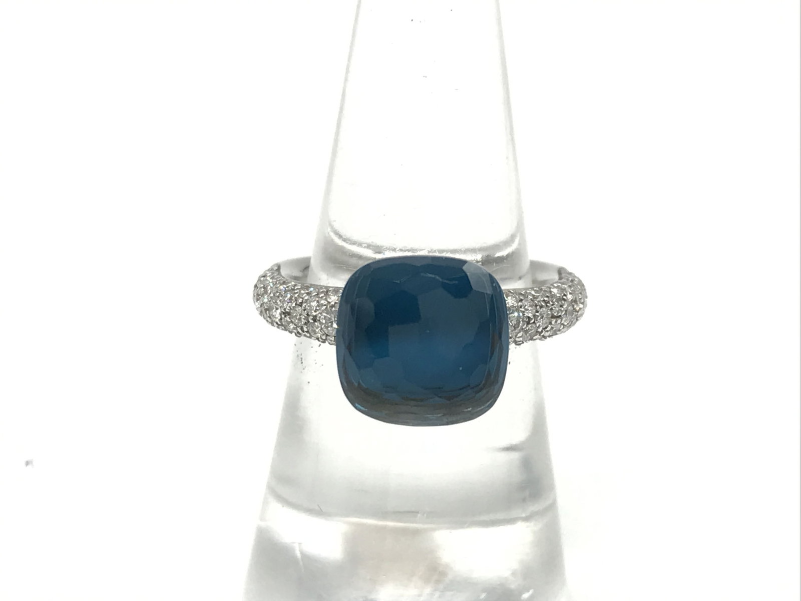 Pomellato Nudo Blue Topaz Diamond 18K Yellow Gold Ring: Description: Elegant Pomellato Nudo ring crafted in solid 18K yellow gold, featuring a large cushion cut blue topaz centerpiece accented by sparkling diamonds along the band. The minimalist open setti