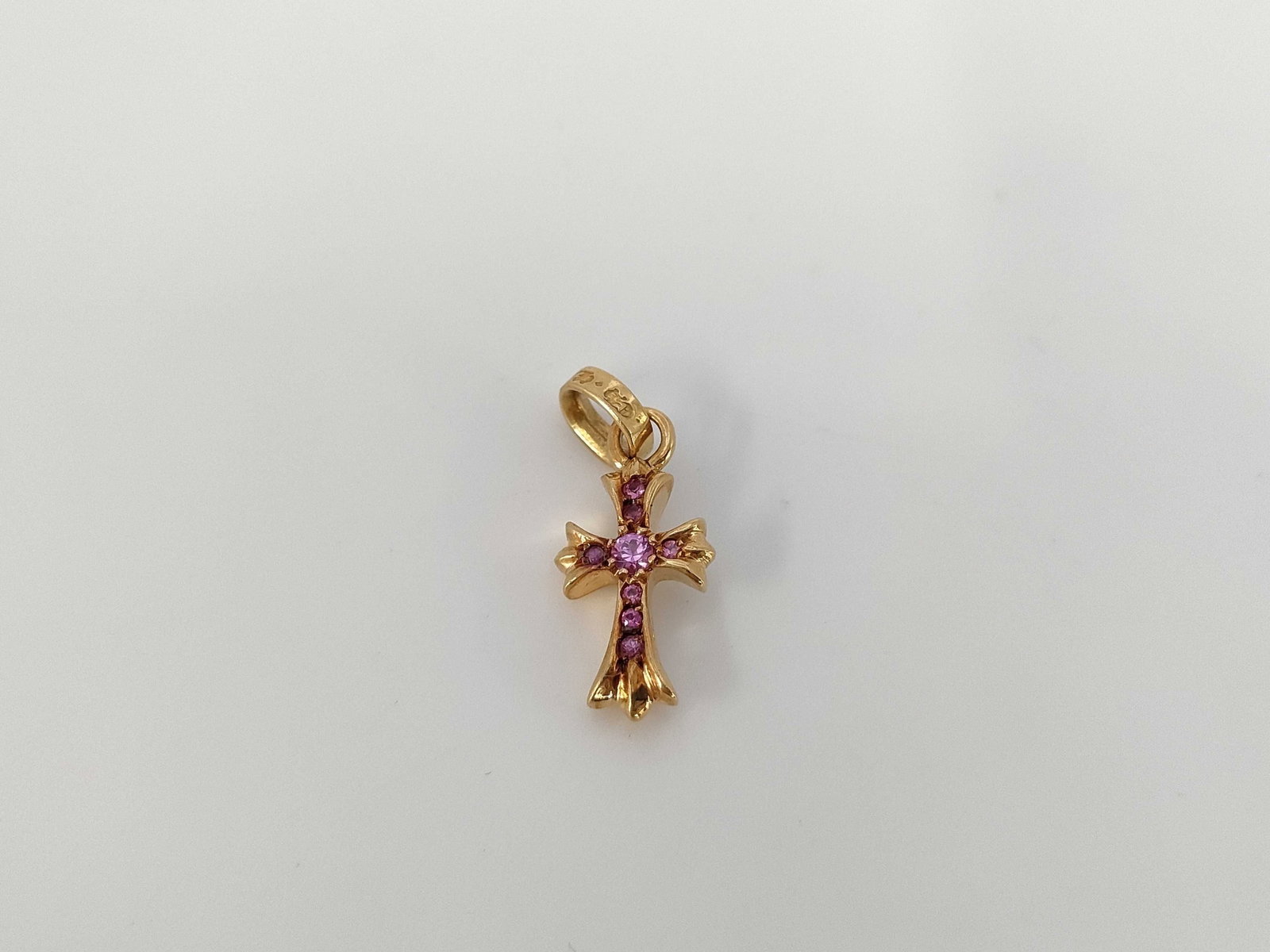 Chrome Hearts Baby Fat Pink Sapphire Cross Gold Pendant: Description: Distinctive Chrome Hearts Baby Fat cross pendant crafted in solid gold and set with vivid pink sapphire gemstones throughout the cross motif. The sculptural gothic form highlights the bra