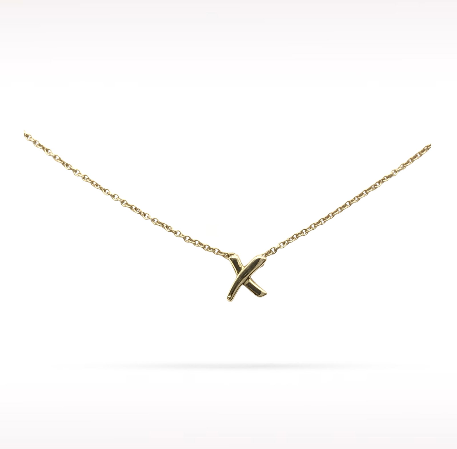 Tiffany & Co. Paloma Picasso X Kiss 18K Yellow Gold Pendant Necklace: Description: Tiffany & Co. Paloma Picasso X Kiss pendant necklace crafted in 18K yellow gold. Designed by Paloma Picasso, the iconic X Kiss motif symbolizes love, unity, and enduring connection. F