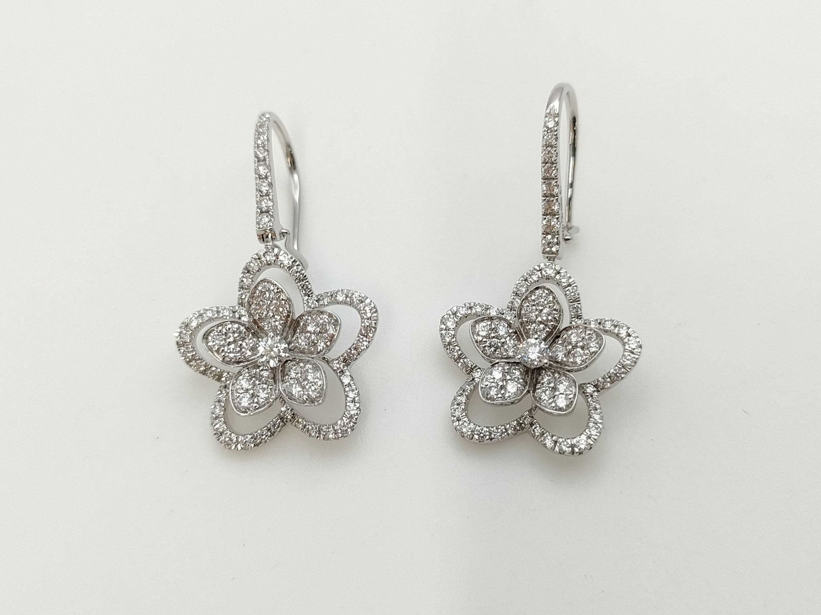 Graff Wildflower Diamond 18K White Gold Earrings: Description: Elegant Graff Wildflower earrings crafted in 18K white gold and set with brilliant cut diamonds. The design features layered floral motifs composed of delicate diamond set petals, creatin