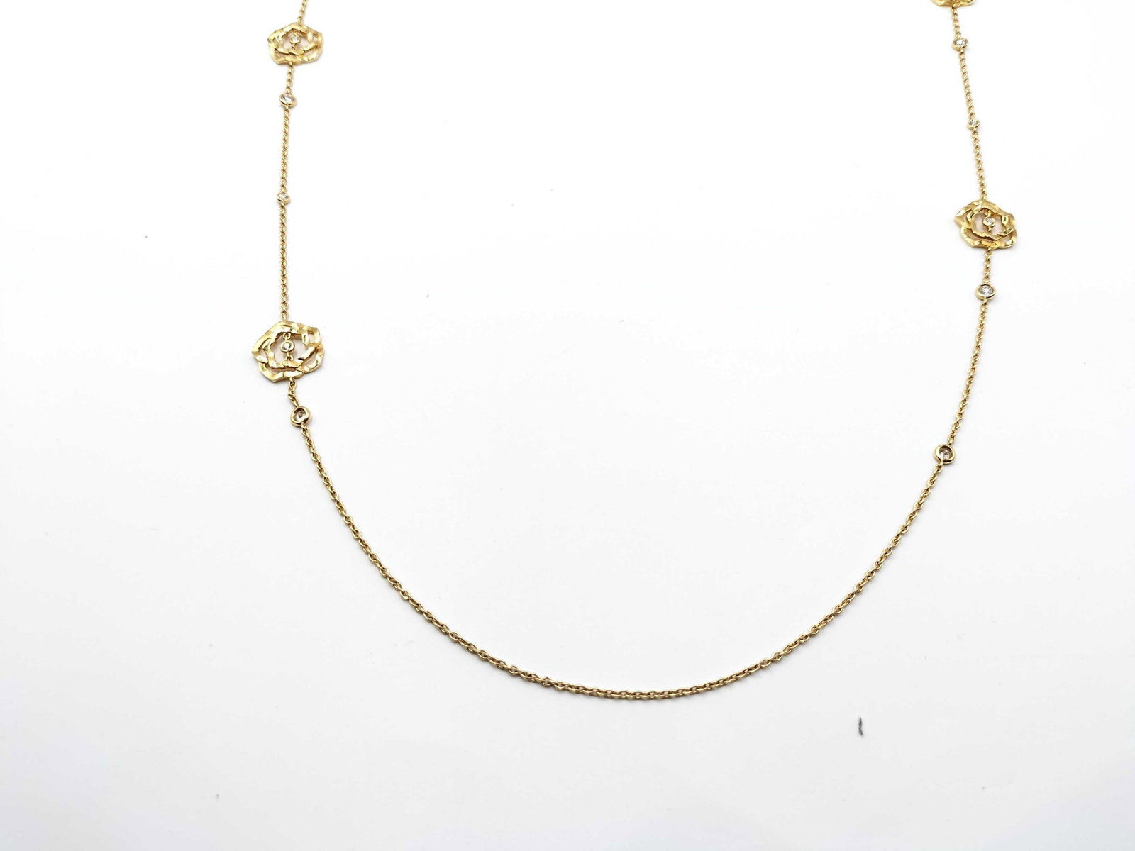 Piaget Rose Diamond 18K Yellow Gold Station Long Necklace: Description: Elegant Piaget necklace crafted in solid 18K yellow gold featuring delicate rose motifs set with brilliant diamonds. The floral elements are spaced along the chain, creating a graceful an