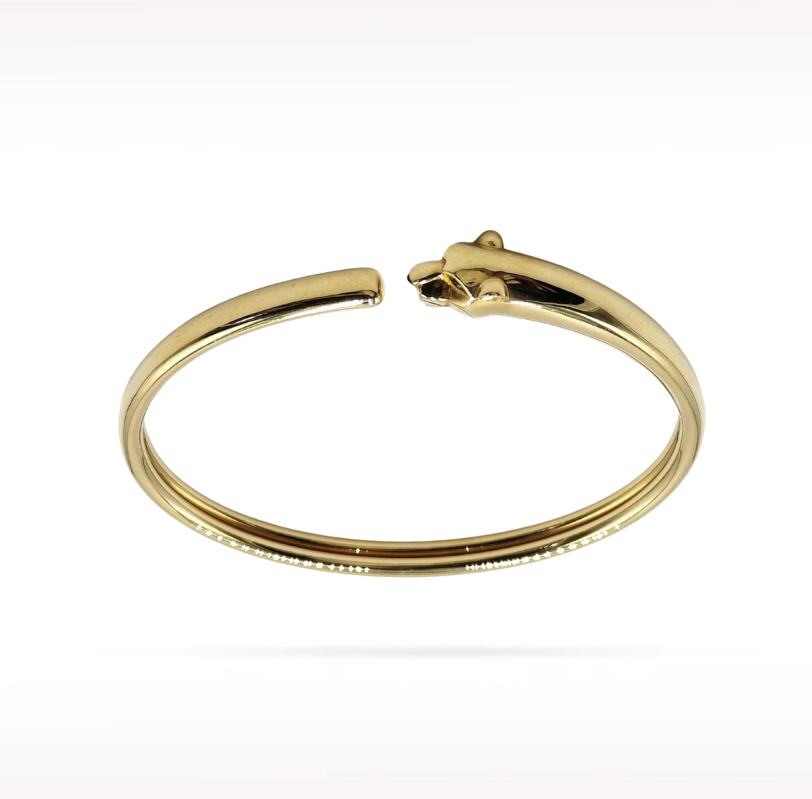 Cartier Panthere Tsavorite Eyes 18K Yellow Gold Cuff Bracelet: Description: Cartier Panthere cuff bracelet crafted in 18K yellow gold and accented with vivid tsavorite eyes. From the iconic Panthere collection, this elegant cuff features Cartier's celebrated pant