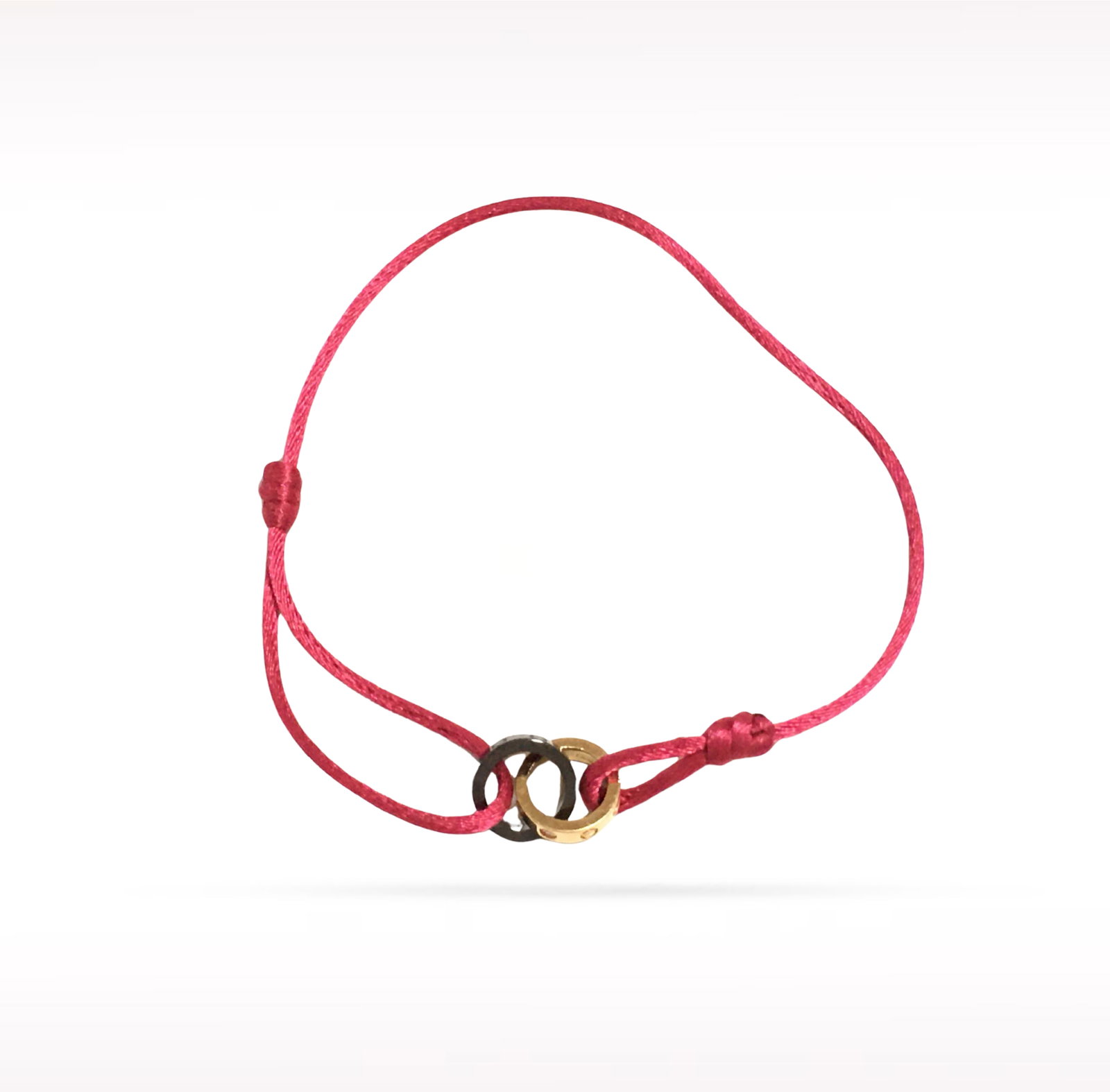 Cartier LOVE 18K Rose Gold Black Ceramic Ring Red Cord Bracelet: Description: Cartier LOVE bracelet crafted in 18K rose gold and featuring a black ceramic LOVE ring motif on a signature red cord bracelet. From the iconic LOVE collection, this contemporary design co