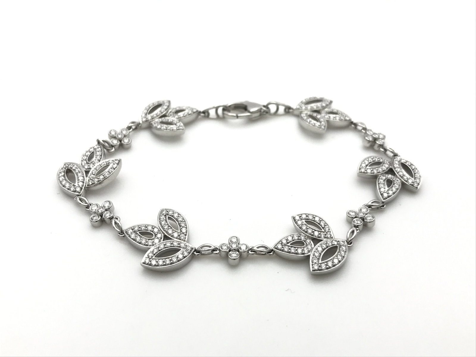 Harry Winston Lily Flower Cluster Diamond Platinum Bracelet: Description: An elegant Harry Winston Lily Cluster bracelet crafted in platinum and set with brilliant diamonds throughout. The graceful floral-inspired motifs reflect the Maison’s iconic Lily C