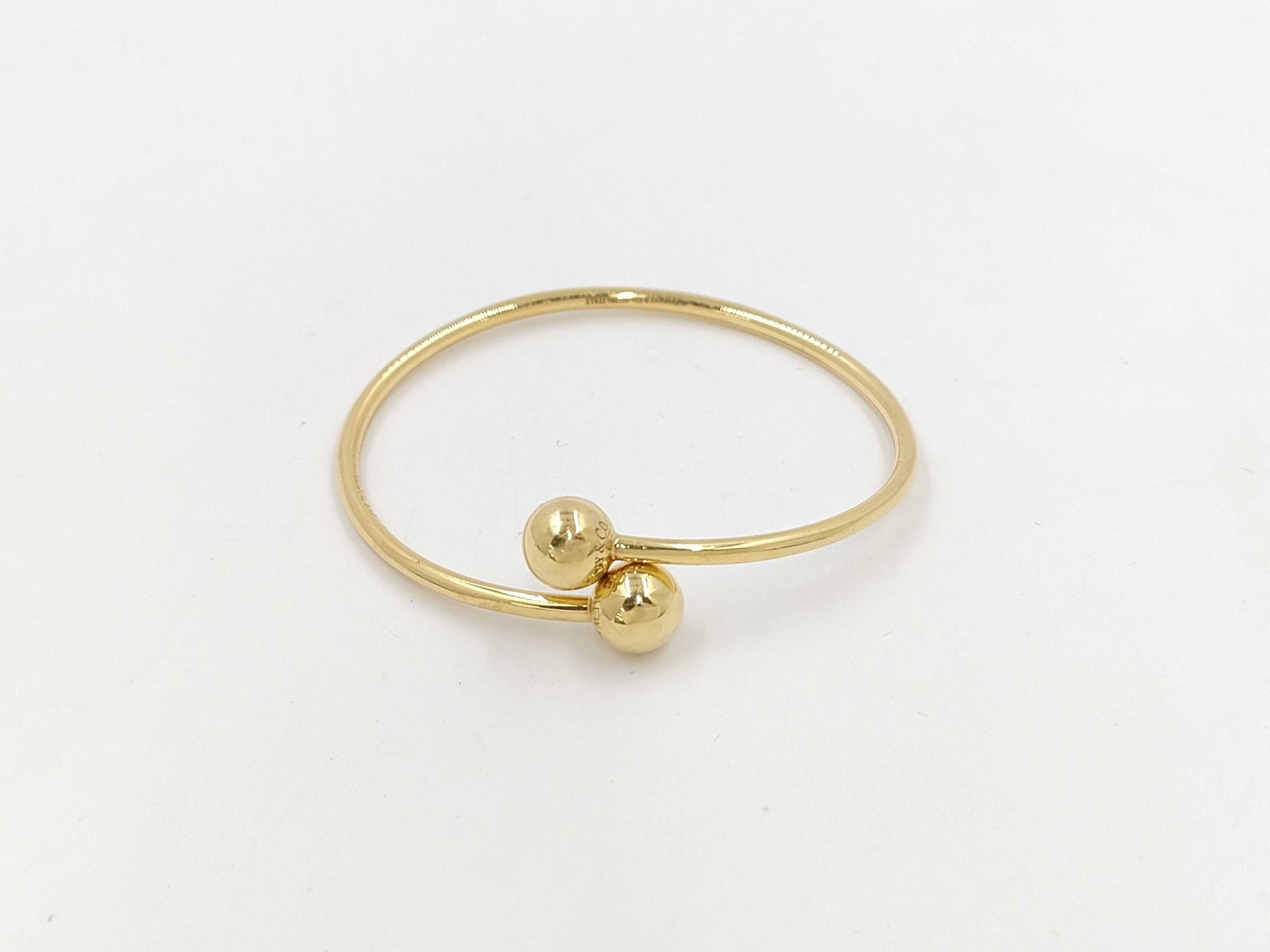 Tiffany & Co. Hardware Ball 18K Yellow Gold Bangle Bracelet: Description: Tiffany & Co. Hardware Ball bangle bracelet crafted in 18K yellow gold. Featuring polished spherical accents and clean contemporary lines, this elegant design reflects the bold yet re