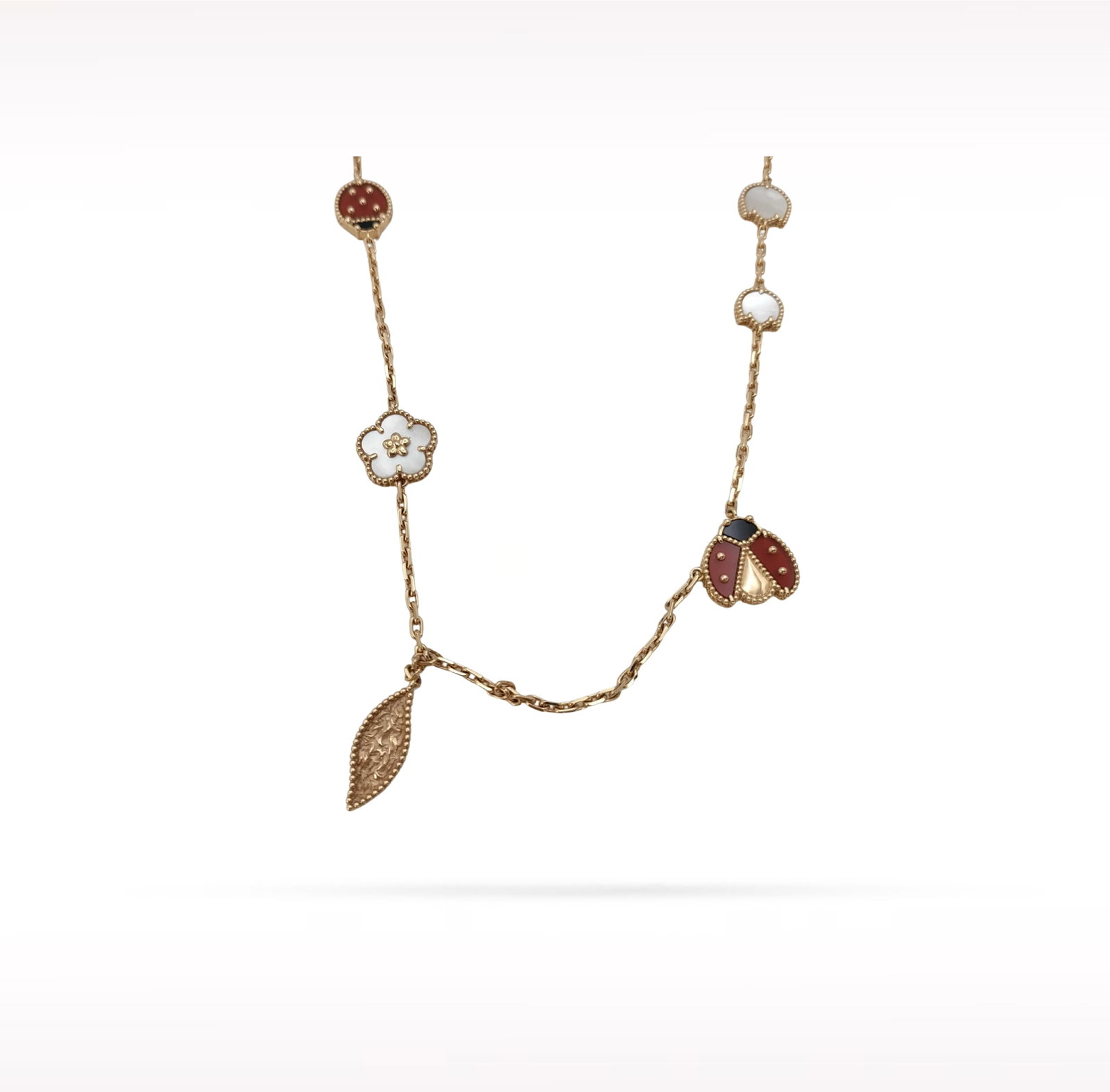 Van Cleef & Arpels Lucky Spring White Mother of Pearl Carnelian 18K Rose Gold 15 Motif Long Necklace: Description: Van Cleef & Arpels Lucky Spring 15 Motif long necklace crafted in 18K rose gold and accented with natural white mother of pearl and carnelian. From the enchanting Lucky Spring collect