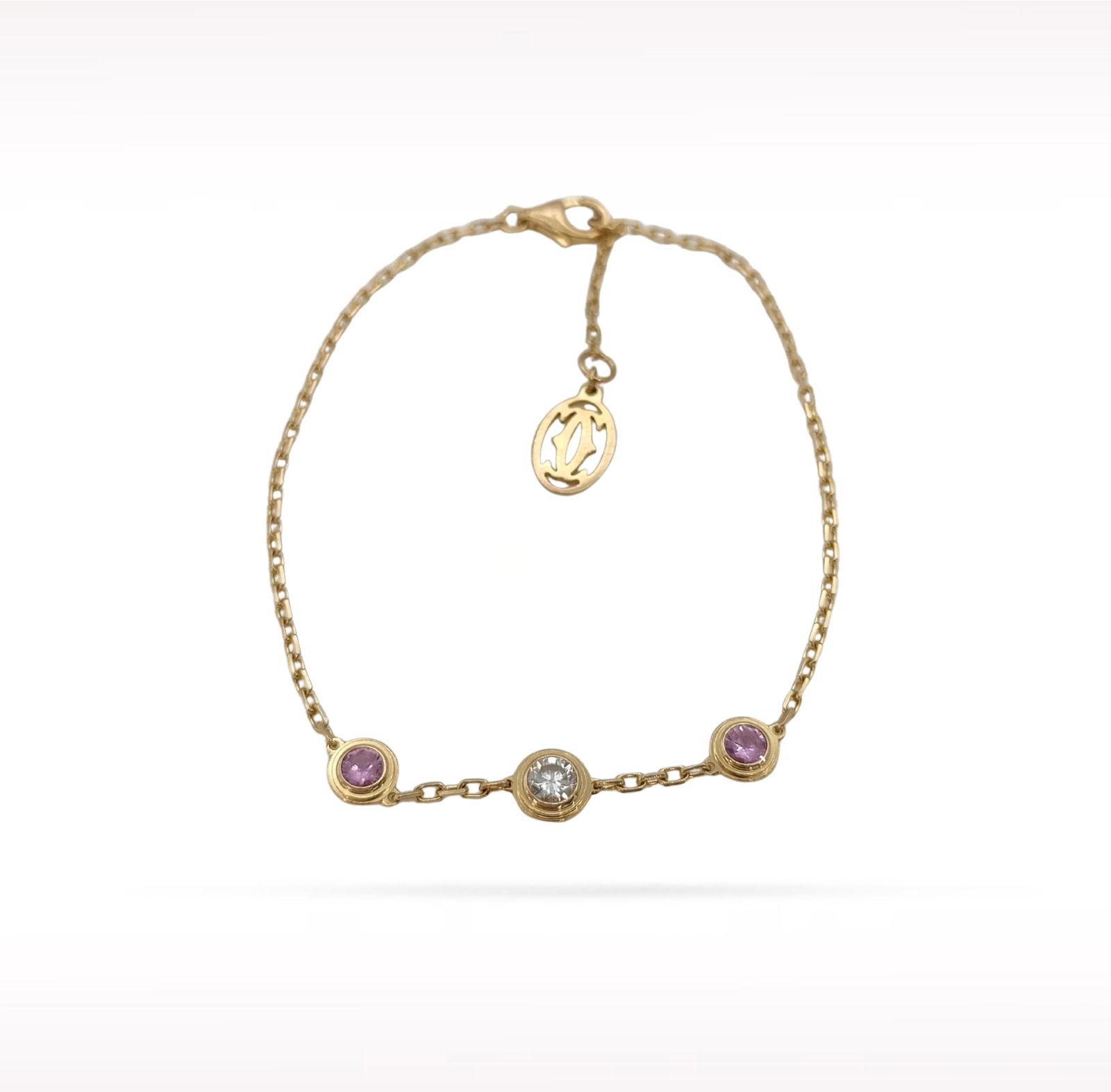 Cartier D?Amour Legers Diamond Pink Sapphire 18K Yellow Gold Bracelet: Description: Cartier D'Amour Legers bracelet crafted in 18K yellow gold and accented with a natural diamond and vibrant pink sapphire. From the elegant D'Amour collection, this refined bracelet featur