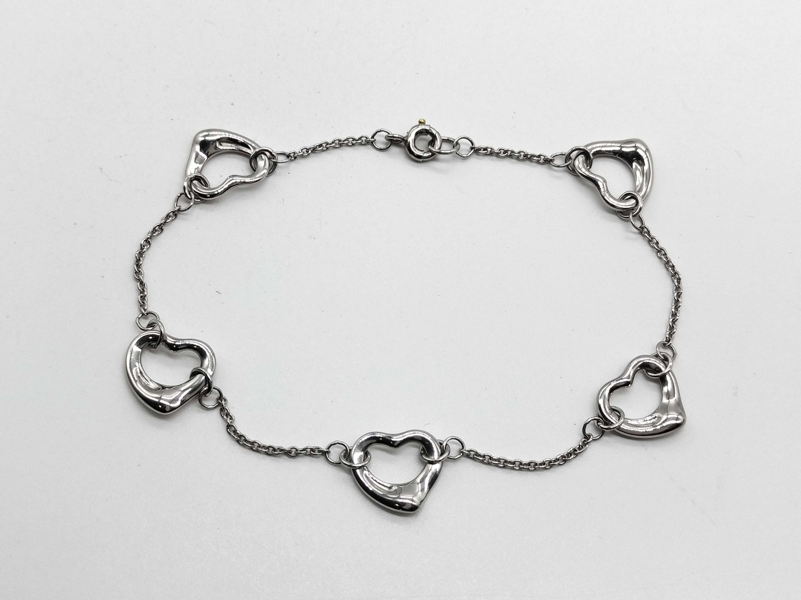 Tiffany & Co. Open Heart 5 Motif Elsa Peretti Platinum Bracelet: Description: Tiffany & Co. Open Heart bracelet designed by Elsa Peretti and crafted in platinum. Featuring five Open Heart motifs arranged along the bracelet, this elegant design showcases the cle