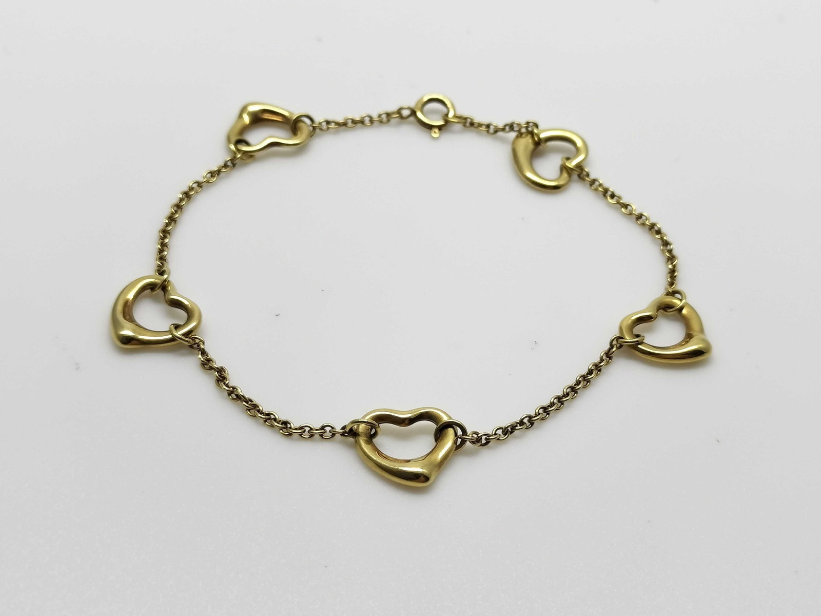 Tiffany & Co. Open Heart 5 Motif Elsa Peretti 18K Yellow Gold Bracelet: Description: Tiffany & Co. Open Heart bracelet designed by Elsa Peretti and crafted in 18K yellow gold. Featuring five Open Heart motifs arranged along the bracelet, this elegant design showcases 