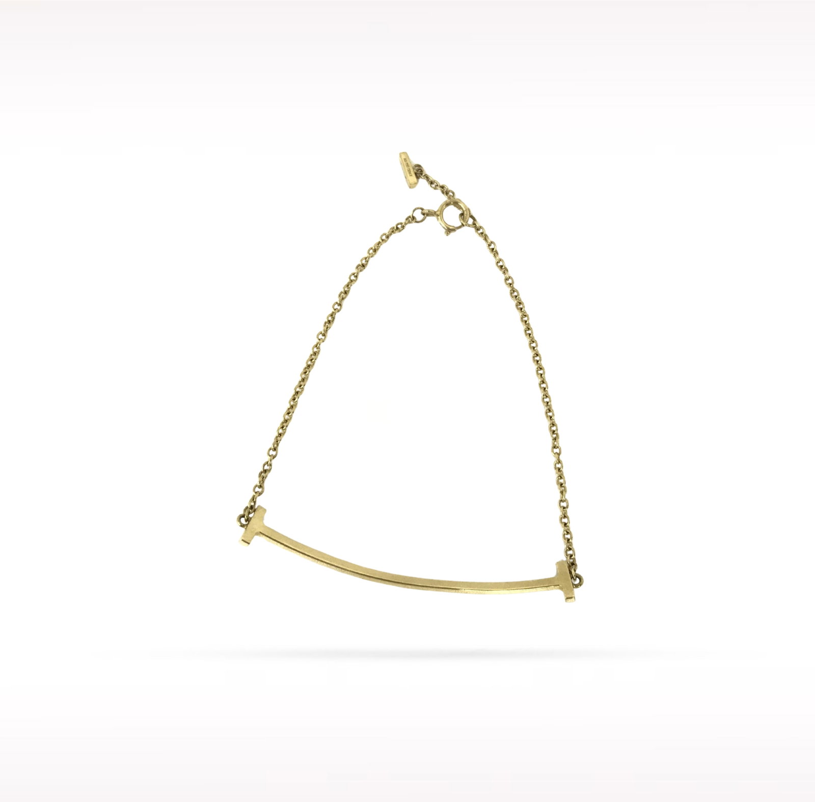 Tiffany & Co. T Smile 18K Yellow Gold Bracelet: Description: Tiffany & Co. T Smile bracelet crafted in 18K yellow gold. From the iconic T collection, this elegant bracelet features the signature T Smile motif with its graceful curved silhouette