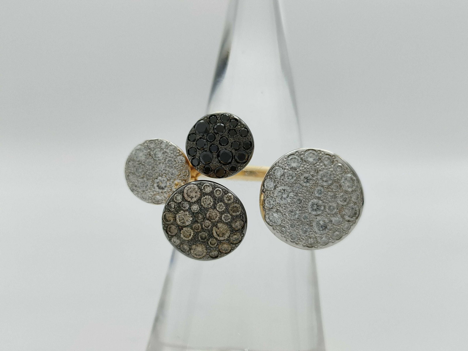 Pomellato Sabbia Fancy Color Black Diamond 18K Gold Ring: Description: Distinctive Pomellato Sabbia ring crafted in solid 18K gold, featuring multiple circular motifs set with pavé diamonds in contrasting tones. The design combines white, brown, and bla