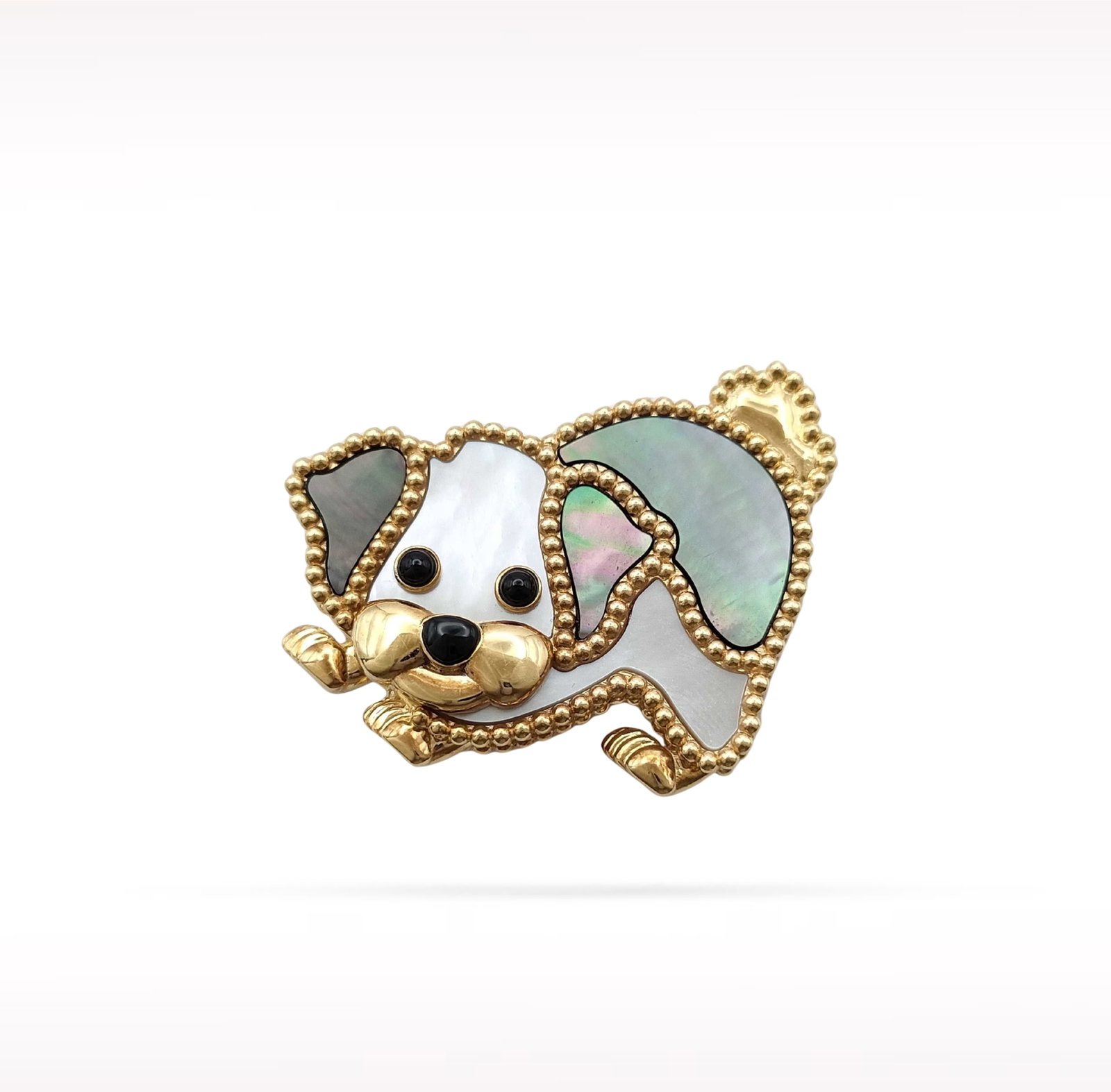 Van Cleef & Arpels Lucky Animals Dog Mother of Pearl Black Onyx 18K Yellow Gold Brooch: Description: Van Cleef & Arpels Lucky Animals Dog brooch crafted in 18K yellow gold and accented with natural white mother of pearl and black onyx. From the charming Lucky Animals collection, this