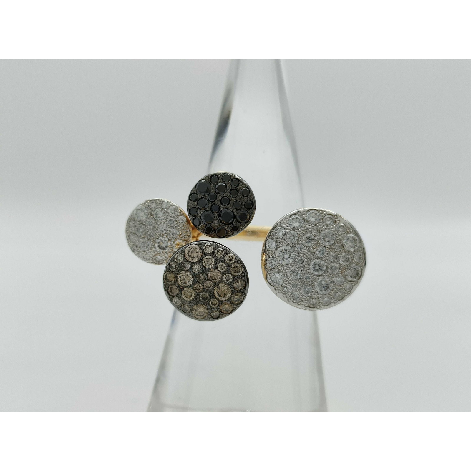Pomellato Sabbia Fancy Color Black Diamond 18K Gold Ring: Description: Distinctive Pomellato Sabbia ring crafted in solid 18K gold, featuring multiple circular motifs set with pavé diamonds in contrasting tones. The design combines white, brown, and bla