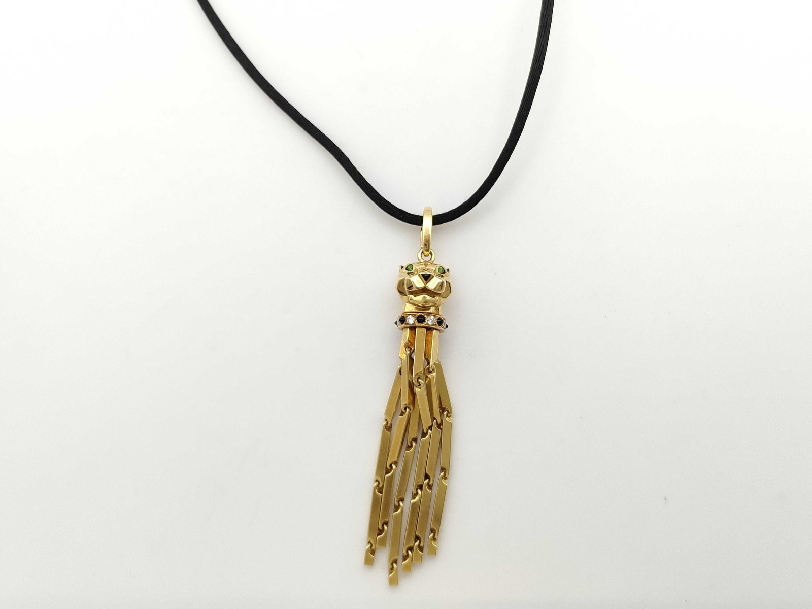 Cartier Panthere 18K Yellow Gold Drop Pendant Necklace with Black Cord Tassel: Description: Rare vintage Cartier Panthere drop pendant necklace crafted in 18K yellow gold and presented on a classic black cord. The design features a sculptural Cartier Panthere motif suspending a 