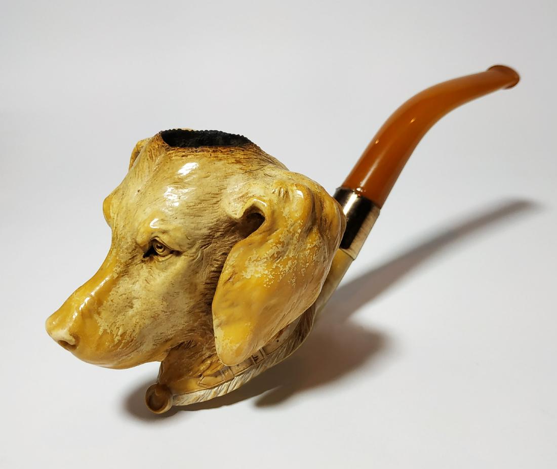 Impressive meerschaum pipe, gold elements: Carved pipe in a shape of a dog, in the center a gold ring (signed), in a very good condition, light flaws. signed of glowing on the handle. length- 19 cm