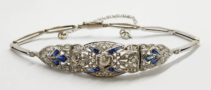 Antique platinum Art Deco diamond and sapphire bracelet: The Deco bracelet is studded with old cut diamonds and blue sapphires of different sizes. The central stone is 0.15ct. Security chain attached. hallmarked inner dimension: 5.4cm weight: 6.9 grams