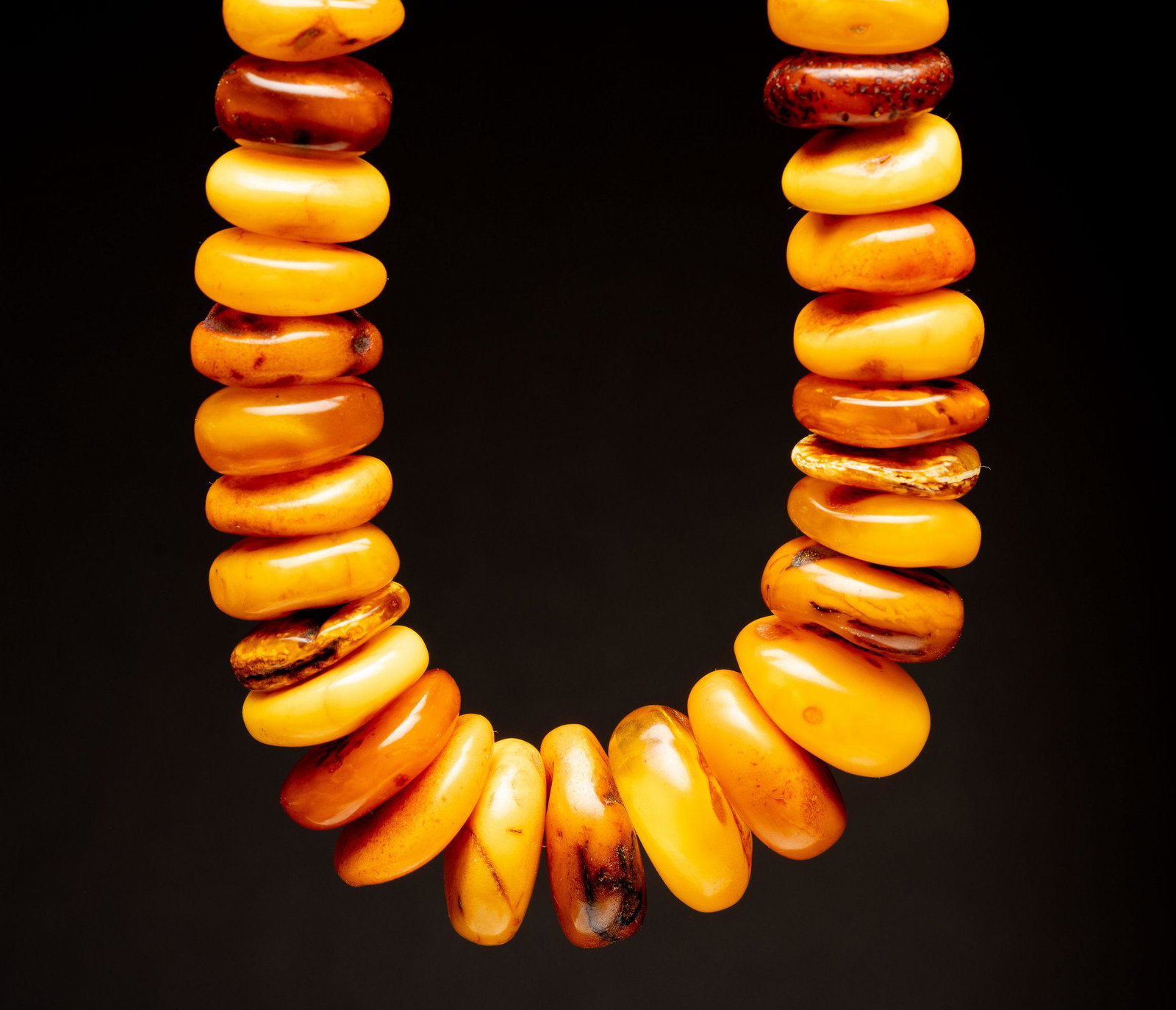 A large amber necklace.- North Africa chinese islamic: The necklace is comprised of 58 amber beads of different sizes and shades. some chips to some of the beads. length when closed: 30 cm weight: 279 grams dimensions of amber beads: 17*12mm - 36*15mm