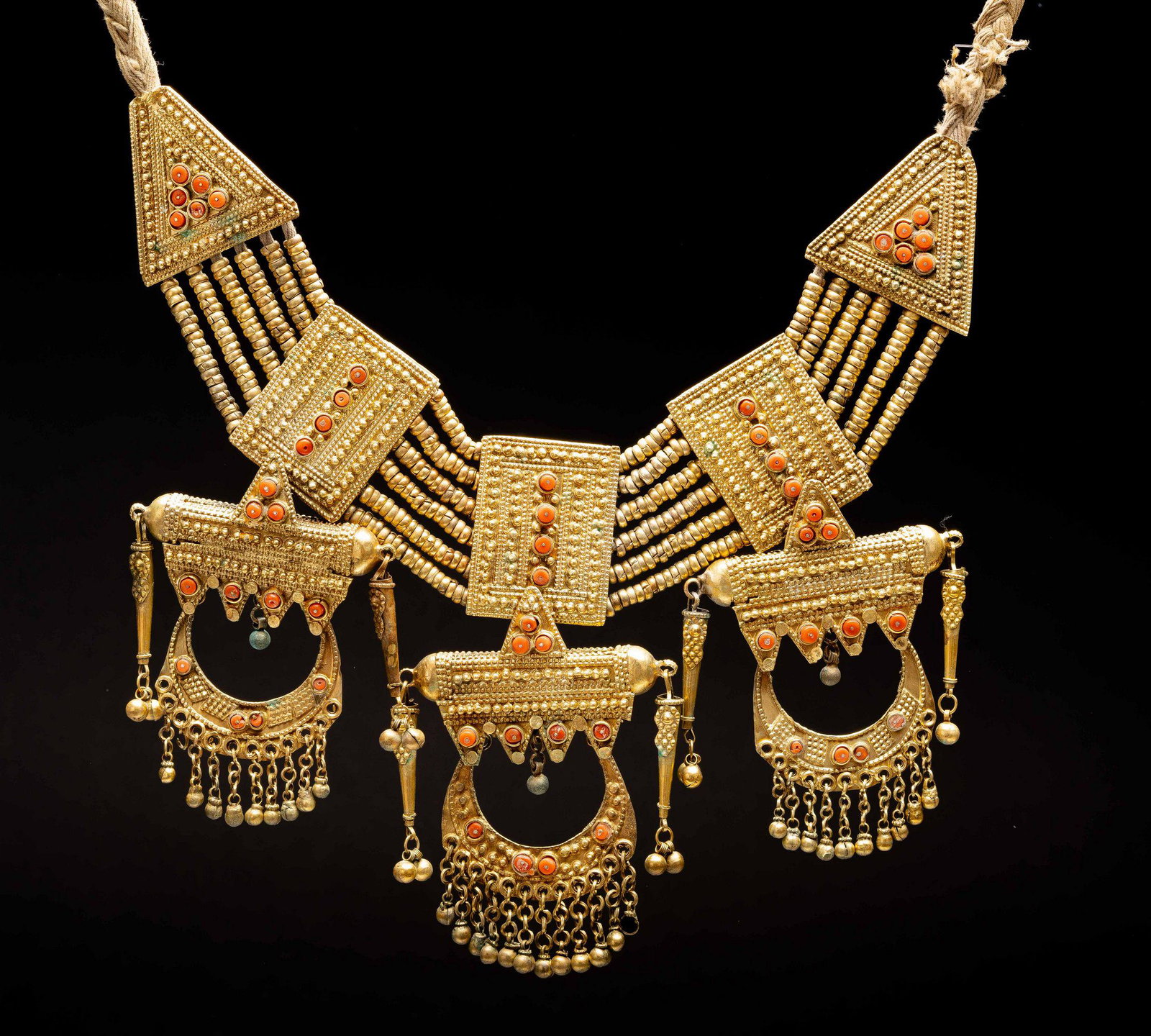 A massive gilded silver and cora necklac Jewish islamic: The massive necklace is comprised of two triangular pendants ( tadahrif) with six rows of gilded silver beads linking between each rectangular plaque. On the bottom are K'tab pendants with crescent sh