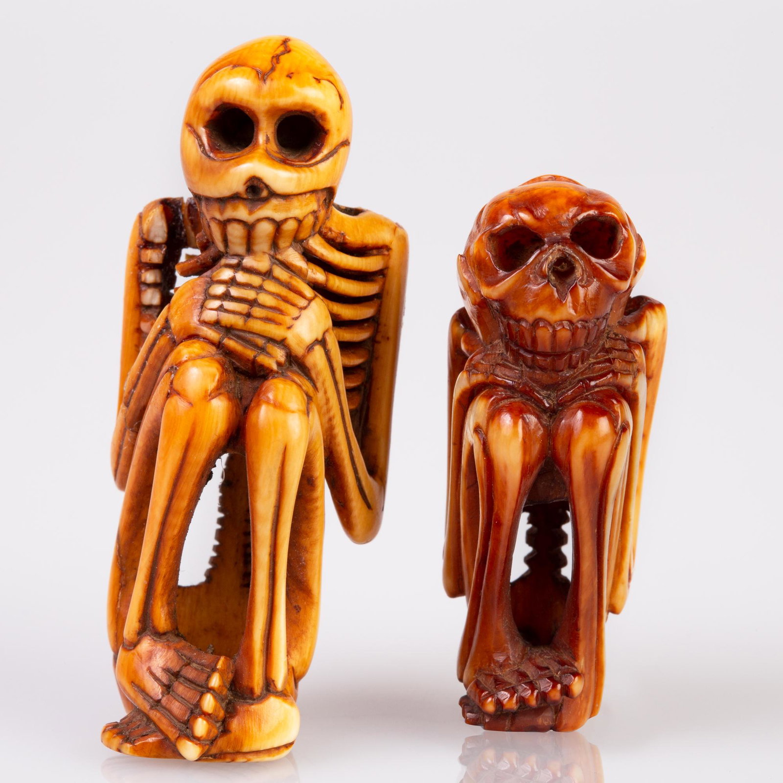 fine antler / bone netsuke: 2 old seated skeleton netsuke. One big one small. Upper part of big one is fractured at the shoulder and ribbs, big one : H 5.6 cm, W 2.2 cm; smal one: H 4.4 cm, W 2.1 cm
