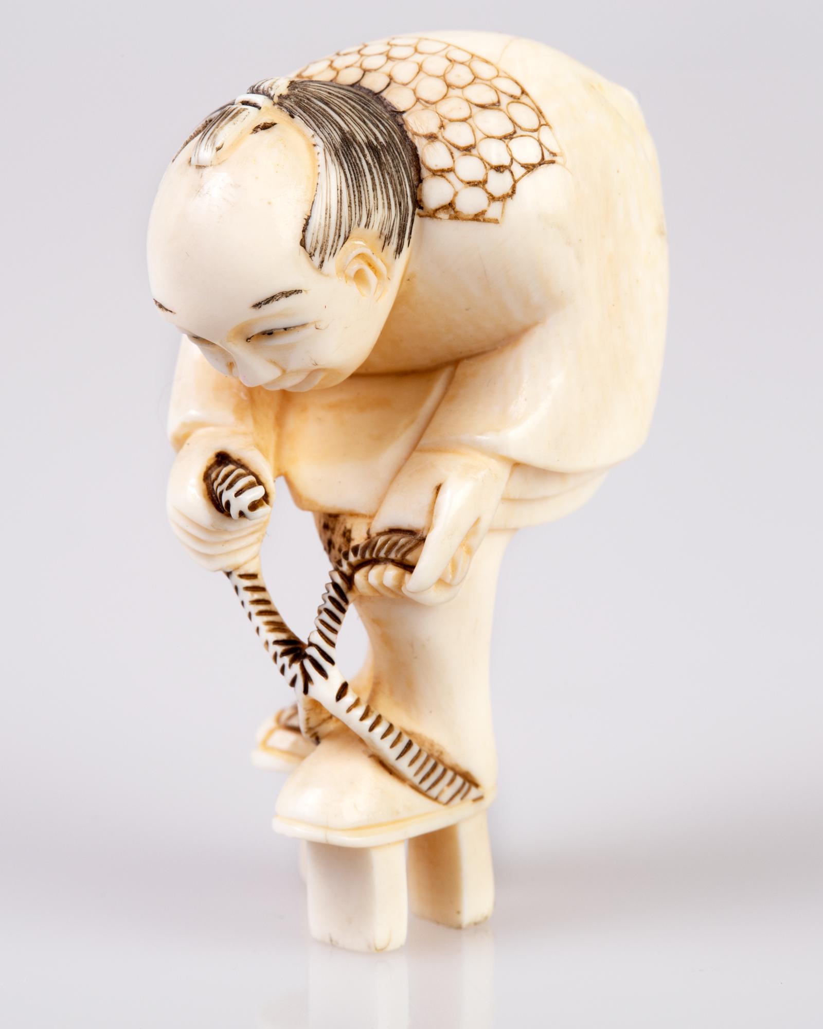 fine antler / bone netsuke: An old netsuke, depicting a man tying his wood sandals.Signed. H 4.4 cm, W 2 cm