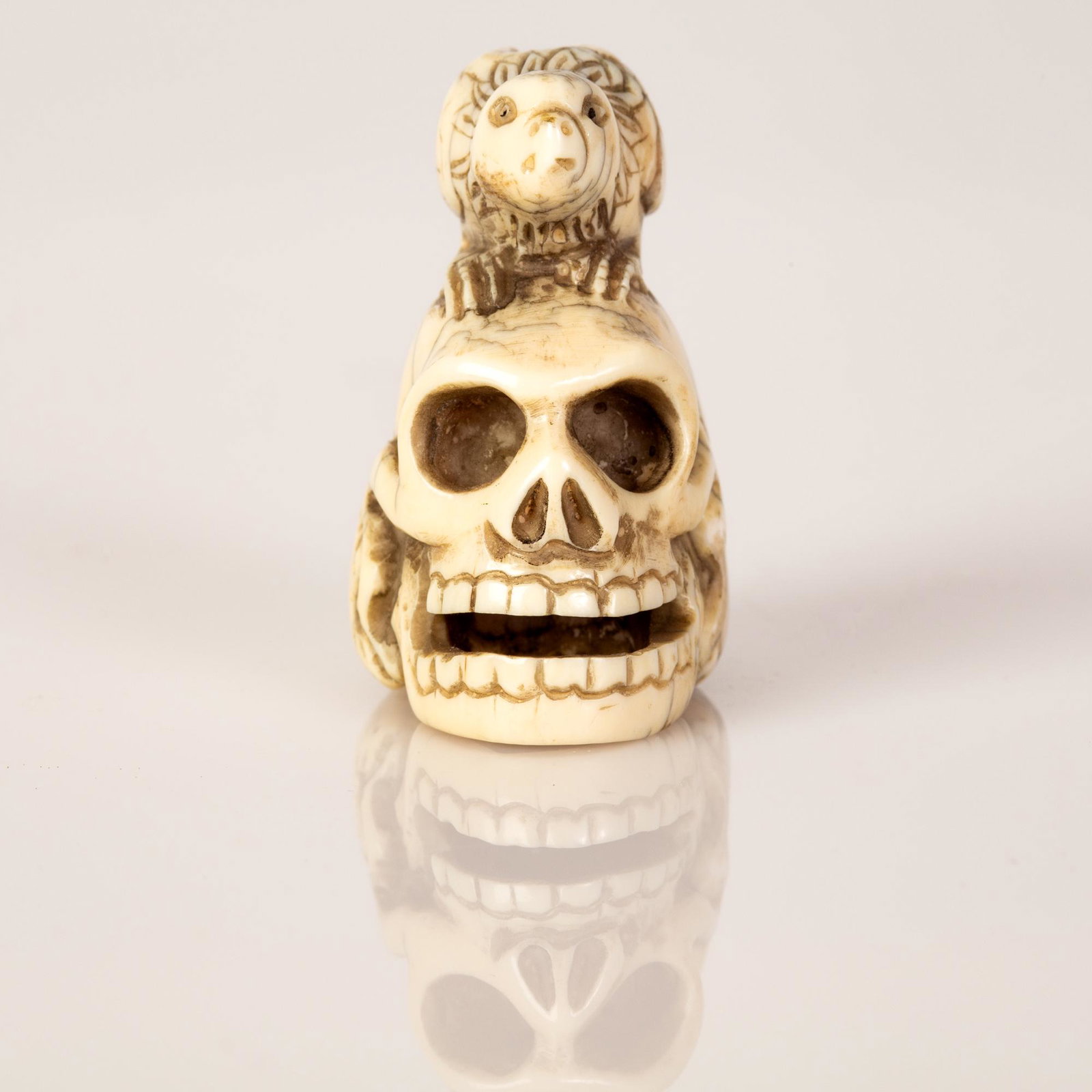 Old Japanese Bone Netsuke Bird on a Skull: Old Japanese Bone Netsuke in the figure of a bird on a skull, minor cracks oldness damages. High quality crafting. Height: 4 cm.