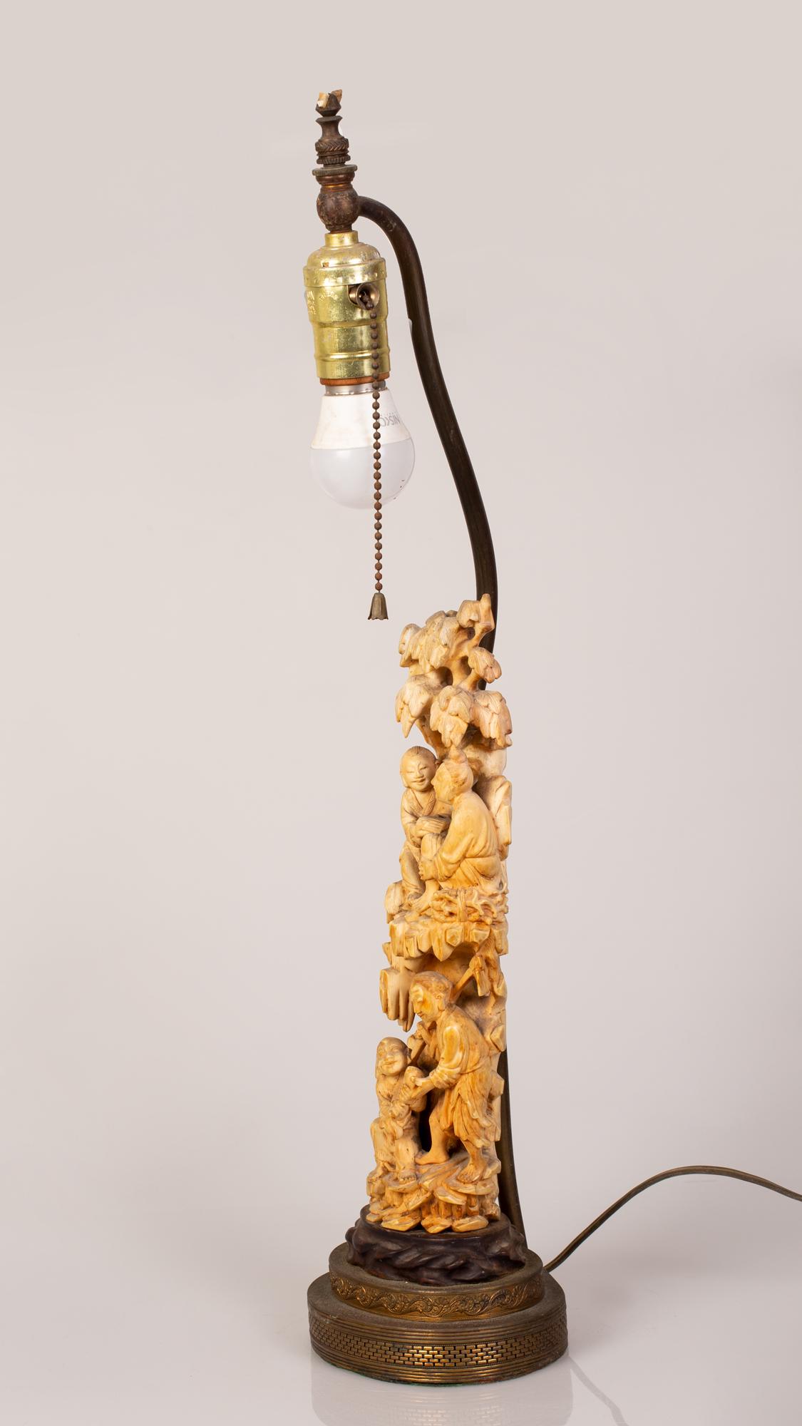 Table Lamp Integrated w/ Old Chinese Sculpture Group of: Table Lamp Integrated with an Old Chinese Sculpture in the figure of a Group of Farmers and Fishermen In Trade on a Mountainside. Situated on a wood stand. Large impressive sculpture. The sculpture he
