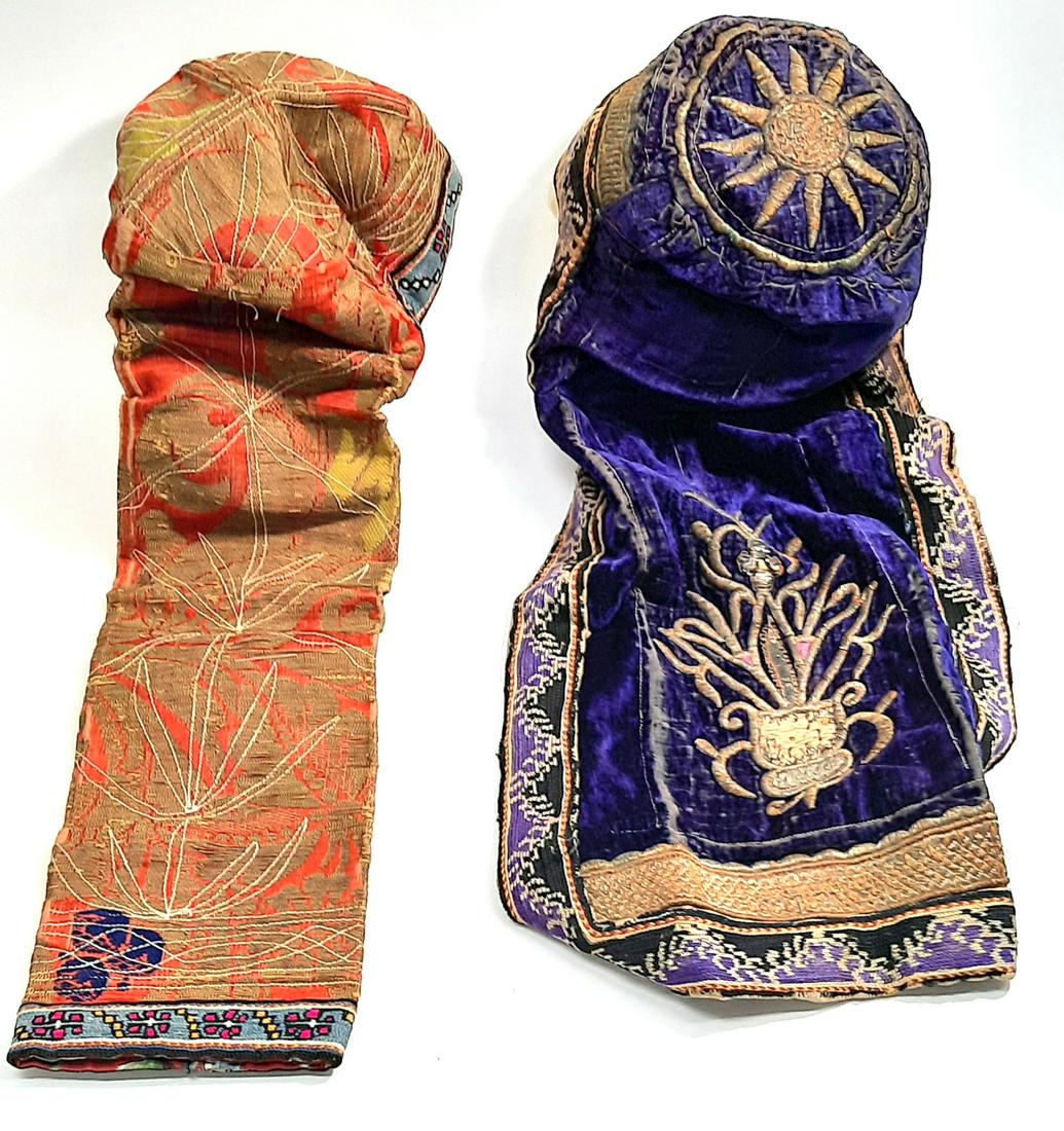 2 Islamic embroidered ladies hats. )1 silver wire(: 1. purple velvet ground with silver wire organic motif 19th c\ length: 57 cm. some fraying to the velvet. some silver wire missing 2. orange ground organic motif length: 53 cm