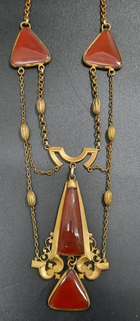 An Antique Arts and Crafts Carnelian Necklace: constructed in an architectural design with four custom cut carnelian cabochons, with filigree elements accents the necklace. Condition: The necklace is in overall very good condition with minor peeli
