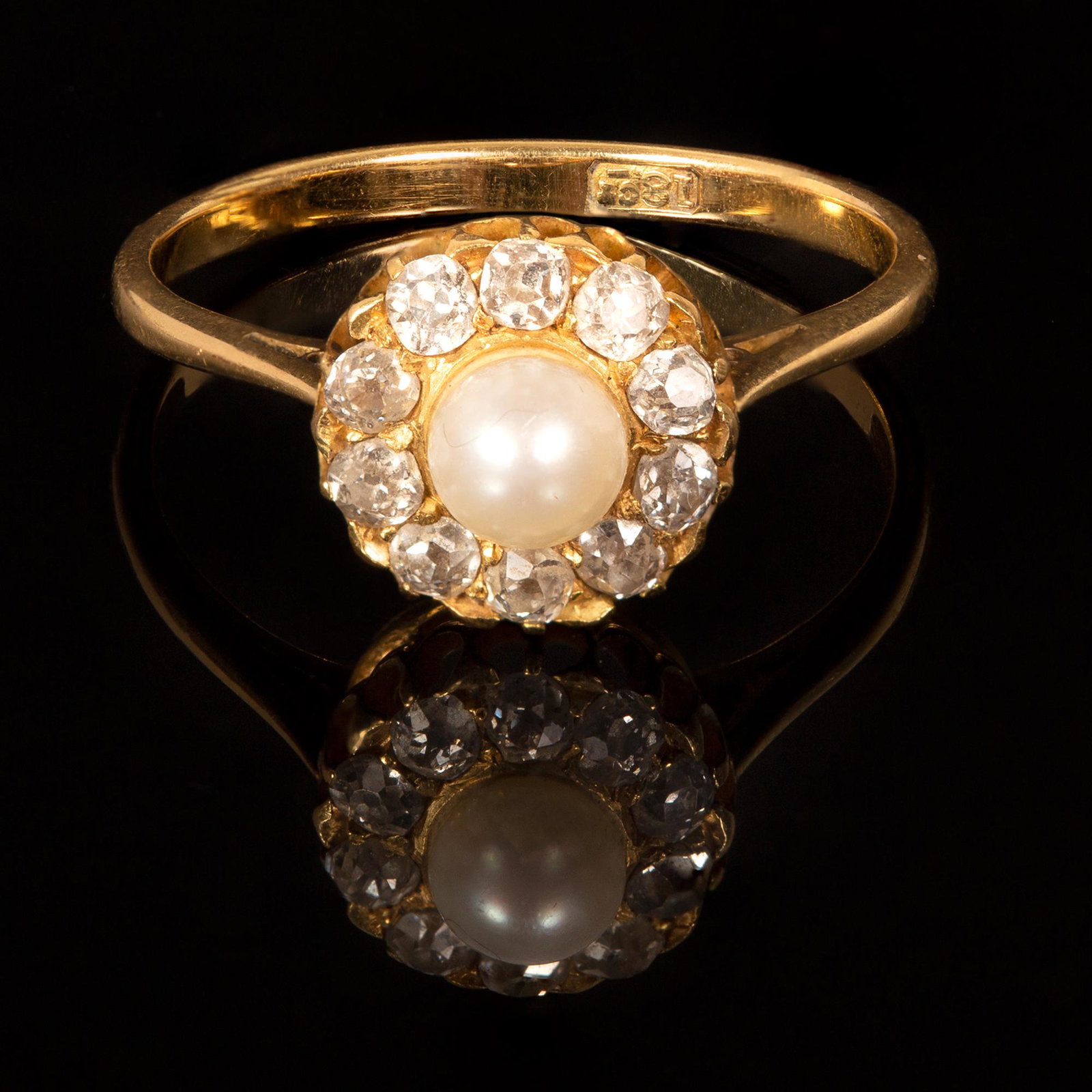 An Antique British 18K Yellow Gold, Natural Pearl and: in a halo style containing one round natural pearl measuring 4.4 mm in diameter and 10 old mind cut natural diamonds weighing approximately 0.50 carat total. Stamp: 18ct. Weight: 2.7 grams Size: 7 Con