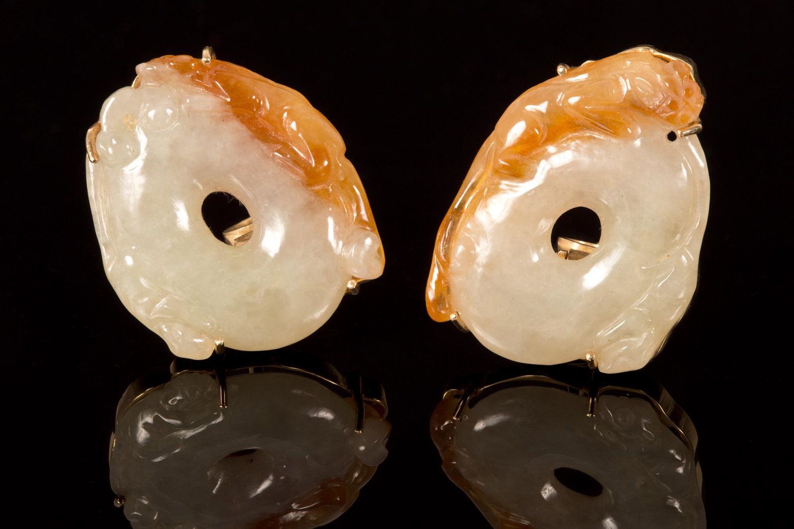 Pair of Chinese 14K Gold, Jadeite Jade Earrings: yellow gold earrings with posts and hinged clip backs, containing two carved natural color white (mutton fat) and yellow jadeite jade disks measuring approximately 30 x 26 mm. Weight: 28.7 grams Stamp