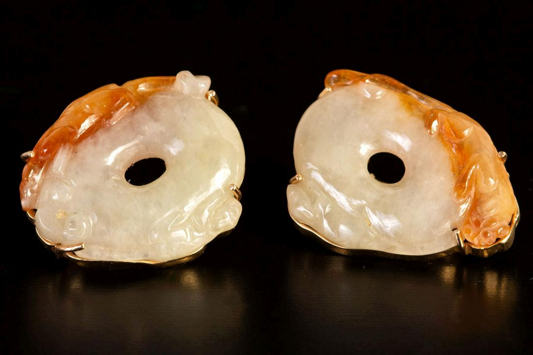 Pair of Chinese 14K Gold, Jadeite Jade Earrings: Yellow gold earrings with posts and hinged clip backs, containing two carved natural color white (mutton fat) and yellow Jadeite Jade disks measuring approximately 30 x 26 mm. Weight: 28.7 grams Stamp