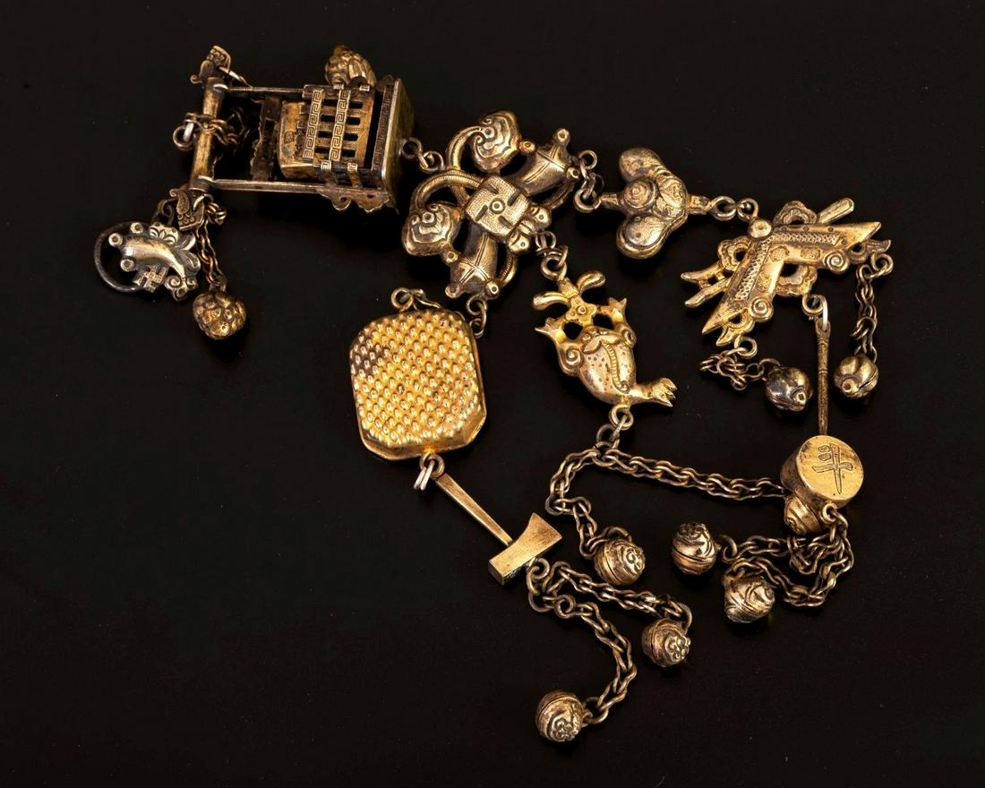 Rare chatelaine chain made of gilded silver - China Qing dynasty 1850-1880: The jewelry consists of a two-sided plaque decorated with various motifs including: flowers, vegetation, fruitsand among other things a swastika - as a Buddhist symbol. Cut, soldered, cast and gilded.