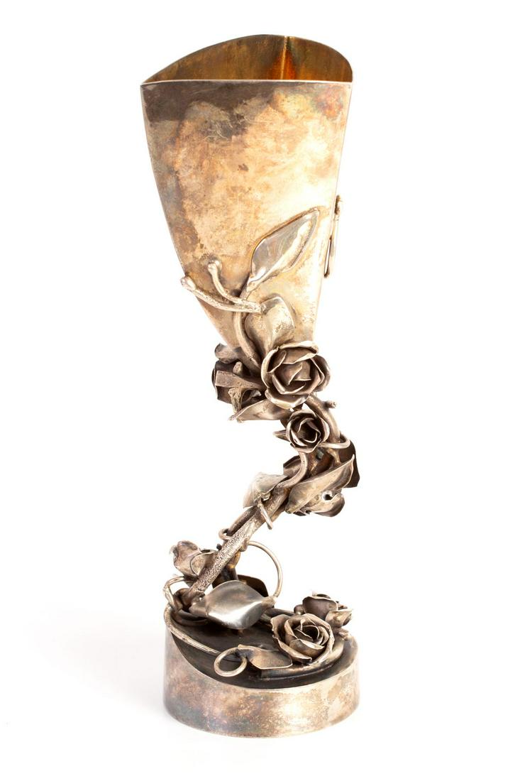 A Silver Kiddush Cup Designed by The Artist Eli Gera: A Kiddush tankard in unique design by artist Eli Gra depicting a branch of roses and leaves. Silver and artist marks. Height 24 cm width 9 cm 441 weight