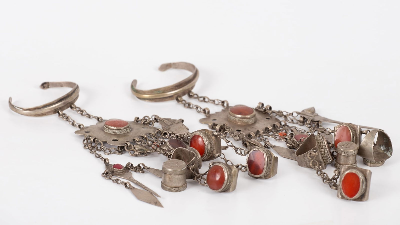 Impressive Central Asia Silver Jewelry, 19th CE: a magnificent pair of silver hand ornaments that are worn as cuff bracelets with affixed rings and finger thimbles. The jewelry is embellished with red carnelian throughout, two red glass beads and tw