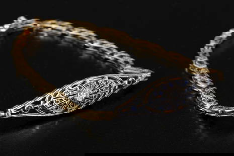14K gold Edwardian bracelet accented w/ diamonds, and sapphires, featuring silver details: An Edwardian bracelet adorned with a 14K gold centerpiece, with its upper part in silver, embellished with a 0.1-carat diamond surrounded by sapphires. The links of the bracelet are also made of 14K y