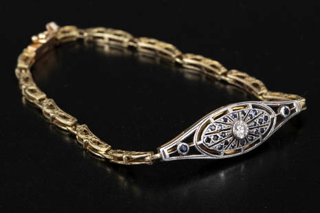 14K gold Edwardian bracelet accented w/ diamonds, and sapphires, featuring silver details: An Edwardian bracelet adorned with a 14K gold centerpiece, with its upper part in silver, embellished with a 0.1-carat diamond surrounded by sapphires. The links of the bracelet are also made of 14K