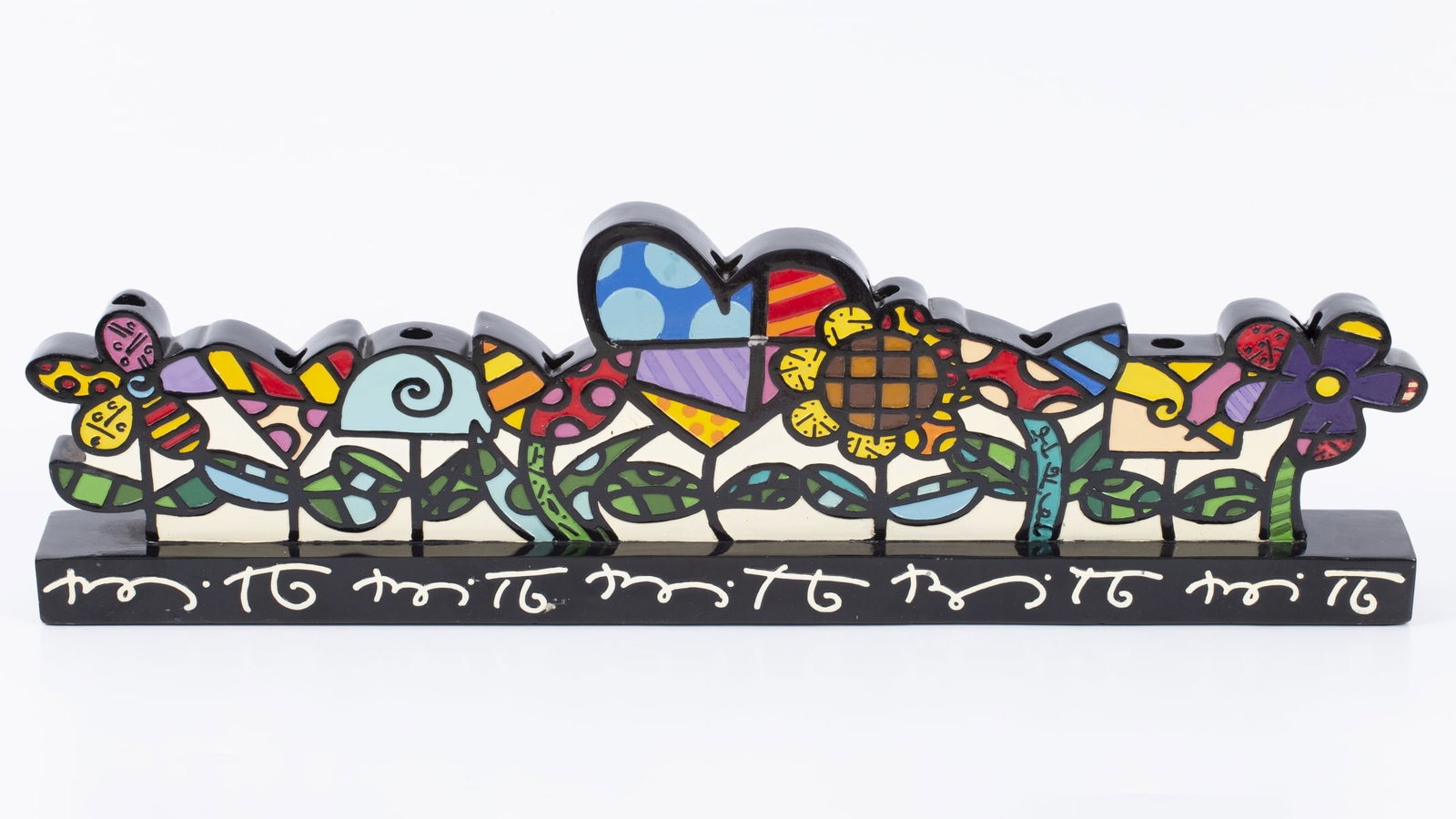 Romero Britto - Menorah decorated with hand painting (Brazil/USA, b. 1963): Romero Britto (Brazil/USA, b. 1963) – wooden menorah decorated with hand enamel. Signed. Dimensions: 15.5X50 cm Romero Brito is a Brazilian neo-pop artist specializing in painting, sculpture, silksc