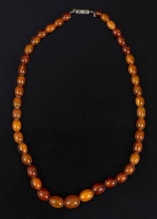 Baltic amber string in graduated sizes: A necklace consisting of Baltic amber beads in a milky honey shade in graduated sizes. Has a silver clasp. The size range of the beads: about 8X7 - 13.5X12 mm. The length of the string:
