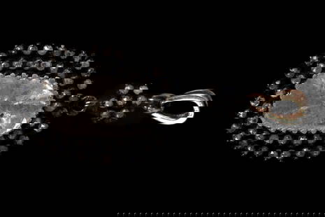 A unique pendant made of silver and gold adorned with diamonds.: A unique pendant made of silver and gold, set with an oval diamond clip in its center, surrounded by a double halo of rose-cut diamonds. Its back is adorned with elegant engraving. It features a 14