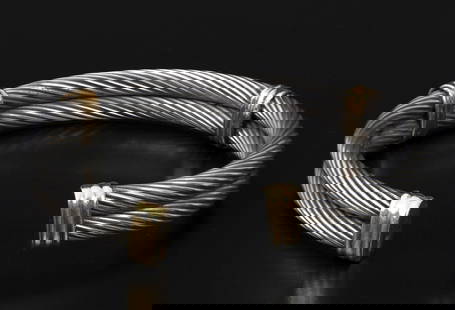 Bangle bracelet made of titanium and 14K gold: A stylish bangle bracelet consists of two titanium rods intertwined with loops made of 14 yellow gold Carat (signed). Inner diameter: about 6 cm Total weight: 51 grams 