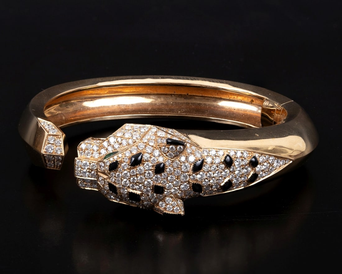 "Panthère de Cartier" - A luxurious gold bracelet adorned with diamonds, emeralds, and onyx stones. (1 of 3)